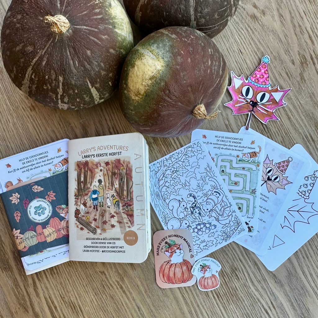 Three decorative pumpkins arranged on a light wood tabletop with a set of autumn-themed printed cards, stickers, and a small booklet spread out in front. No person or animal is present, so this is Product/Packaging rather than Lifestyle.